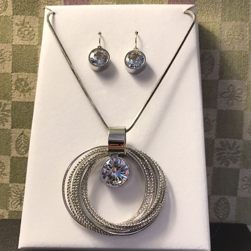 Silver colored necklace w/cubic zirconia pendant/ bangles, matching CZ earrings.